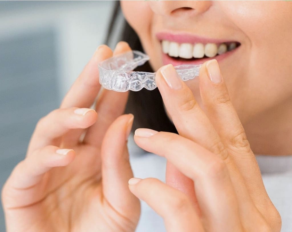 Person holding a clear orthodontic aligner